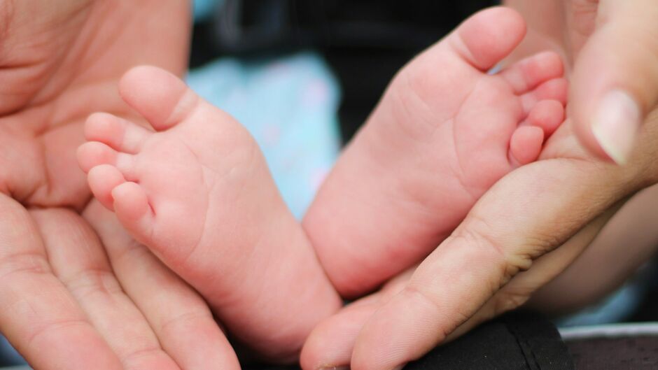 parent hands with baby feet